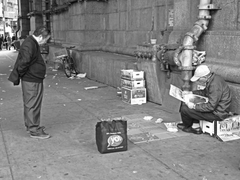 While waiting for his friends to arrive to play Chinese checkers with them, an elderly man reads the daily newspaper under the Manhattan Bridge.