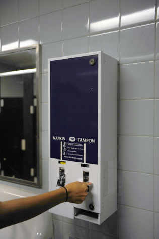 A student uses the new machine in the second floor girls' bathroom to dispense a tampon