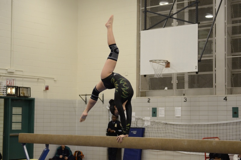 On the balance beam, Elena Michaud ’19 performs a back aerial.