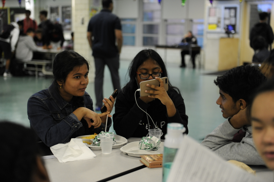 Students spend their lunch period watching shows on their iPhones. 
