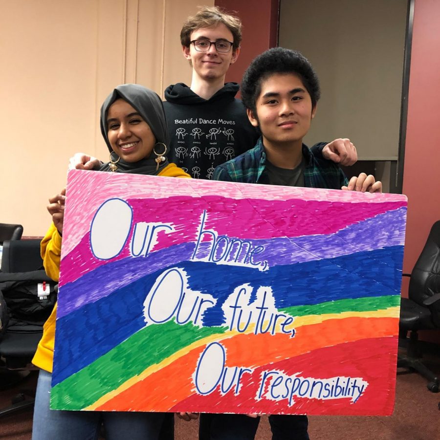 Rajaa Elhassian 19, John Feighery 19, and Peter Alegre 19 pose with a sign that states, Our  home, our future, our responsibility.