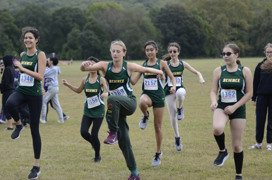 Ninth graders on the Girls’ Cross Country team warm up together before a meet.