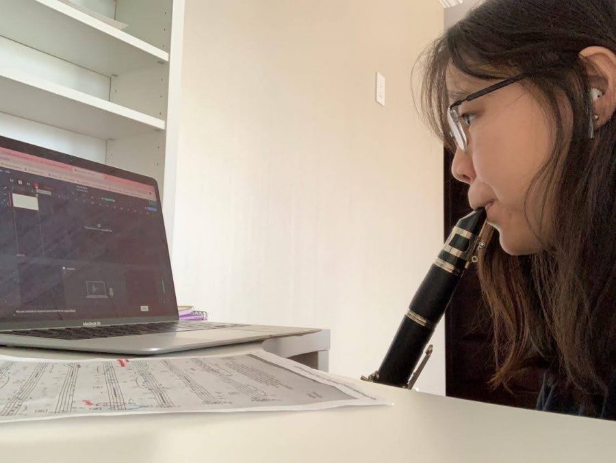 Andrey Lin ’22, a performer in the Bronx Science Concert Band, records her part of a musical piece at home. “I would have loved it if we were able to play in the same room, but we are making the best out of our current situation, given the pandemic,” said Lin.