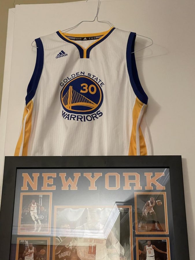 Pictured are two pieces of signed NBA apparel, sold exclusively through the NBA Store, a Stephen Curry Jersey and a Frank Ntilikina Signed Board.

