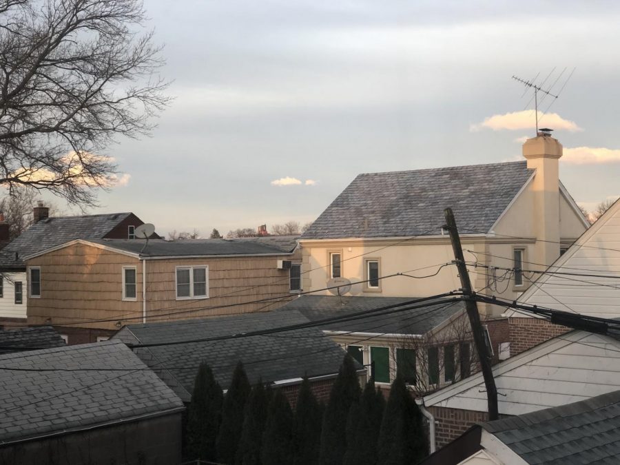 This photo was taken on January 25th, 2021 at 4:17 p.m.; it is similar to what I saw from my bedroom window in Bayside, Queens on January 11th, 2021 at 3:13 p.m. The slated, gabled rooftops complement a muted blue sky.