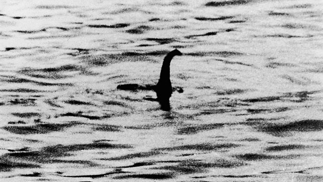 The famous “Surgeon’s photo” of the Loch Ness monster, purportedly taken by Robert Kenneth Wilson in 1934 during a fishing trip north with his friend, Maurice Chambers.  It is by far the most famous photo of Nessie, and helped to skyrocket the cryptid’s popularity after being sold to the Daily Mail in 1934 after popular sightings of Nessie in 1933.  After Chambers passed away in 1994, personal papers revealed that the photograph was a hoax, having been taken by hunter and filmmaker Marmaduke Arundel Wetherell, having been a sculpture of wood and plastic made by sculptor Christian Spurling that was attached to a toy submarine.  Spurling corroborated the story at the age of 90 in 1993, with the group deciding to have Wilson be the one to put the photo forth to lend credibility to the story as he was a physician.  In spite of its proven falsehood, the Surgeon’s photo is still what many first think of when they hear of the Loch Ness monster -- and could you blame them?  The hoax went on for over 60 years, only definitively ruled out because of testimony by its producers.  The lighting allows the centered figure to remain obscure, yet establishes an iconic silhouette that many recognize.  There is no scale to be given by anything surrounding the subject, so we cannot gauge size, creating more ambiguity.  While color photography did exist in the form of Autochrome, it was rare, and thus understandable that Wilson, just going on a fishing trip, would not have it on his person, with the black and white coloring further obscuring detail and amassing any seams on the sculpture into a single silhouette.

