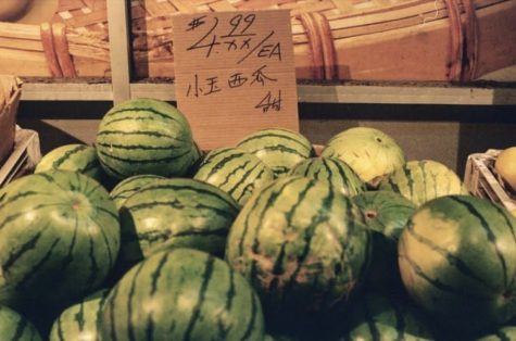 A crate of watermelons sit outside; my father would often slap them to decide which ones were ripest.