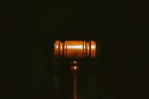 A gavel is used in a court of law by a judge for attention, punctuating a ruling, and solidifying any proclamations. 
