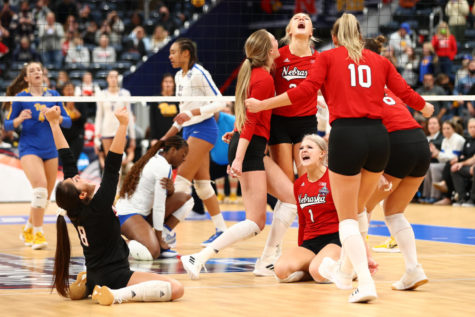 The Nebraska Cornhuskers celebrate dramatically, falling to the ground and exclaiming in glee, after defeating Pittsburgh to advance to the NCAA Finals. 