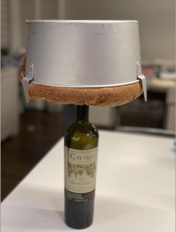 This is the method my family uses for allowing our sponge cake to rise as much as possible. Balancing on top of the wine bottle upside down allows the cake to remain in the pan while also rising high above the pan.