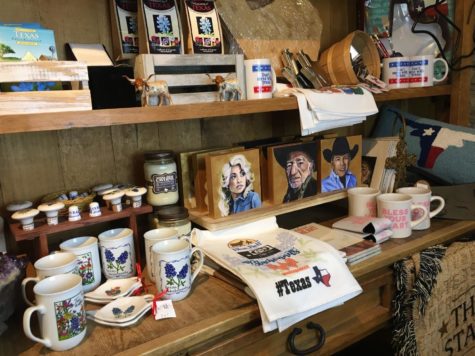 This gift shop corner displays classic Texas emblems like Whataburger merchandise, country music memorabilia, Texas shaped cookie-cutters and canteens, and the Lone Star flag.