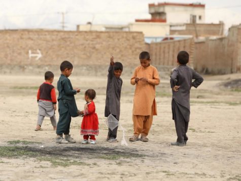 A group of children dressed in red and gray play in Kabul, Afghanistan. This photo was taken on October 7th, 2020, a full year before the Taliban resurgence. During this time, tensions between the US and the Taliban rose once more, with Taliban attacks increasing.