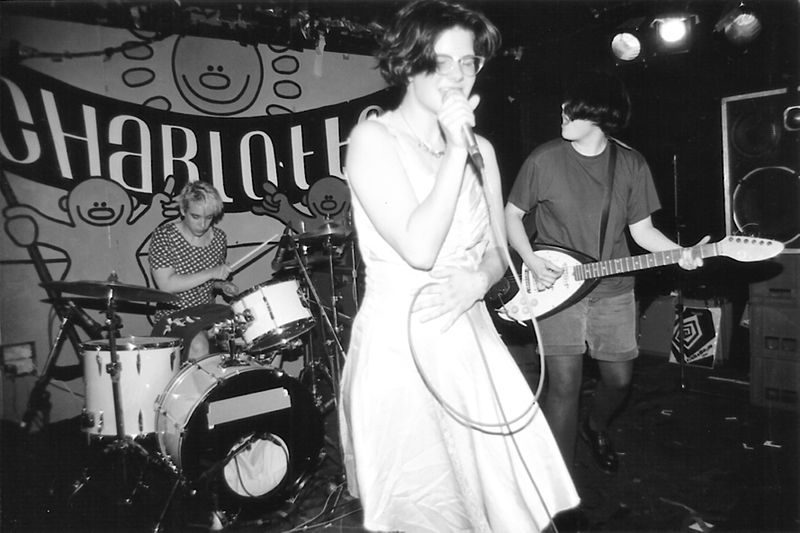 Here+is+a+photo+of+the+lead+singer+Allison+Wolfe+of+Bratmobile+performing+live.+Members+of+Riot+Grrrl+bands+often+wore+very+feminine+attire+to+show+that+femininity+does+not+equal+weakness.