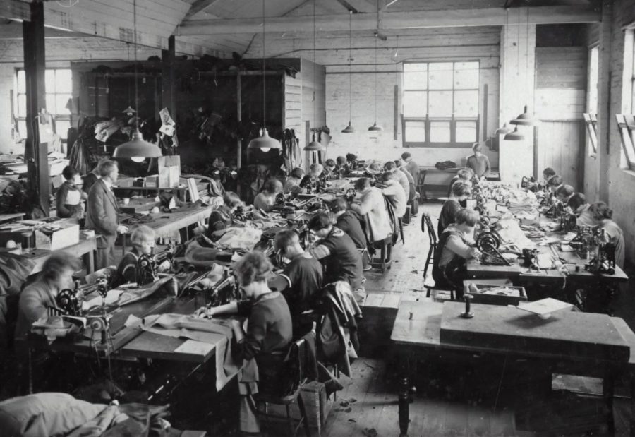 Workers in a twentieth- century factory produce garments.