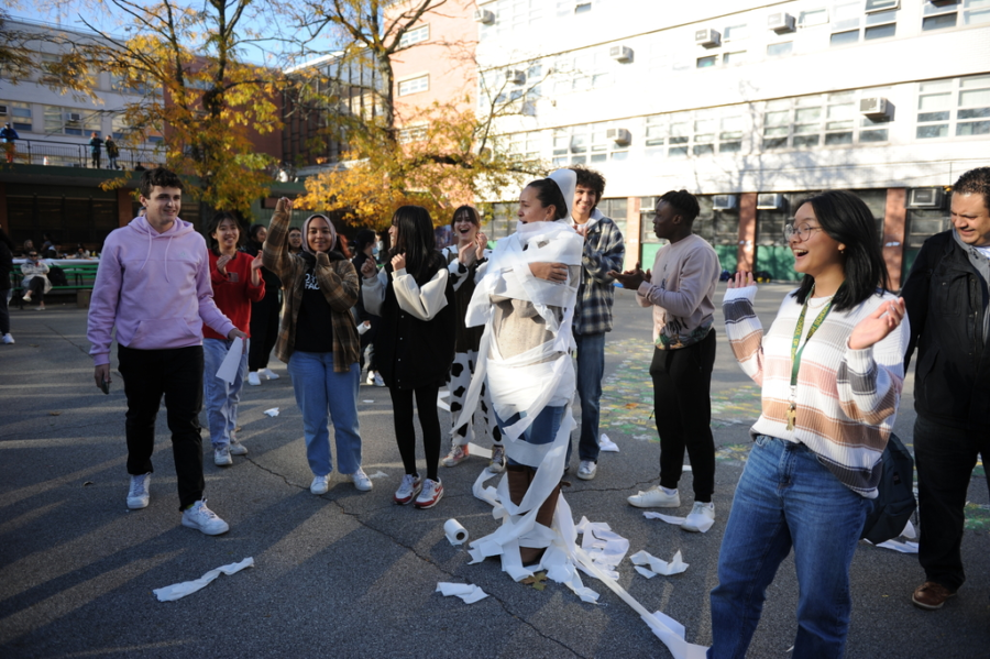 A group of students wrap teachers with toilet paper (willingly on the teachers part) during Bronxtoberfest, a festive activity that also served as a stress reliever. 