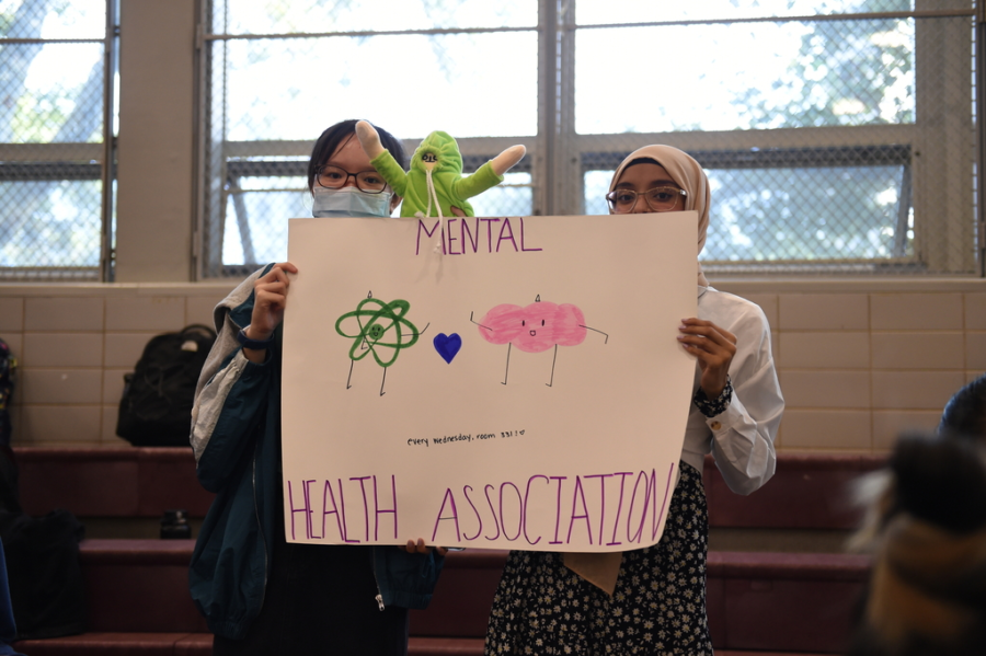 Grace Lin and Siddrual Moonthaha hold up a Mental Health Association poster to advertise for new recruits at the Bronx Science Club Fair. 