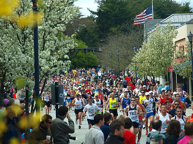 A crowd of runners pushes forward as people watch from the sidelines during the 2010 Boston Marathon. 