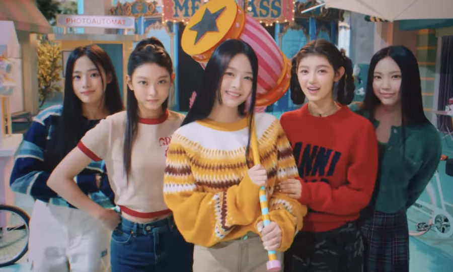 Here, all of the members of NewJeans pose for a group photograph. From Left to Right are Minji, Haerin, Hanni, Danielle, and Hyein. 