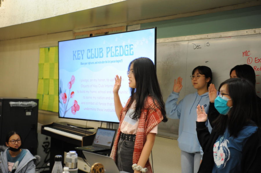 Board members and club members follow Shiya Lin, former President of Key Club, as she states the Key Club pledge. 
