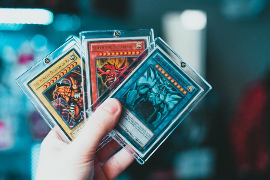 The three powerful Egyptian God Cards are, from left to right: The Winged Dragon of Ra, Slifer the Sky Dragon, and Obelisk the Tormentor. In the first season of Yu-Gi-Oh!, they were owned by Marik/Malik Ishtar, Yugi Muto, and Seto Kaiba respectively. Seto Kaiba founded Duel Academy with dorms based on these cards, making Slifer the worst because of his not-so-friendly feelings towards Yugi, and Obelisk the best because of his ego. The cards’ original Japanese names were: Winged God-Dragon of Ra, Sky Dragon of Osiris, and Giant God-Soldier of Obelisk. The English change from Osiris to Slifer references the 4Kids employee Roger Slifer, who worked on the English dub of Yu-Gi-Oh!. (Photo Credit: Erik McLean / Unsplash)