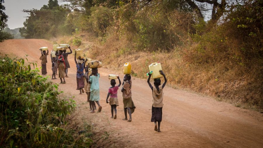 A+group+of+Ugandan+women+and+children+walk+to+get+water+on+a+dirt+road+%E2%80%93+a+common+scene+throughout+much+of+rural+Africa+due+to+a+lack+of+large-scale+public+infrastructure.+%28Photo+Credit%3A+Jeff+Ackley+%2F+Unsplash%29