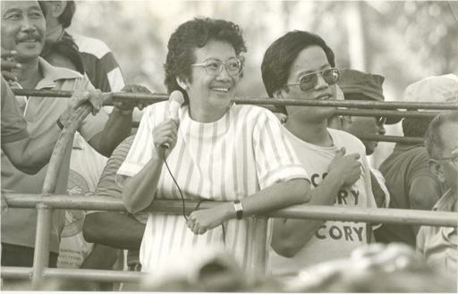 Featured above are two protestors who took to the streets against Ferdinand Marcos. One of them wears a shirt in support of Corazon “Cory” Aquino, the rightful winner of the 1986 election. [Photo Credit: National Library of the Philippines (distributed by Philippine Presidential Museum and Library), Public domain, via Wikimedia Commons]