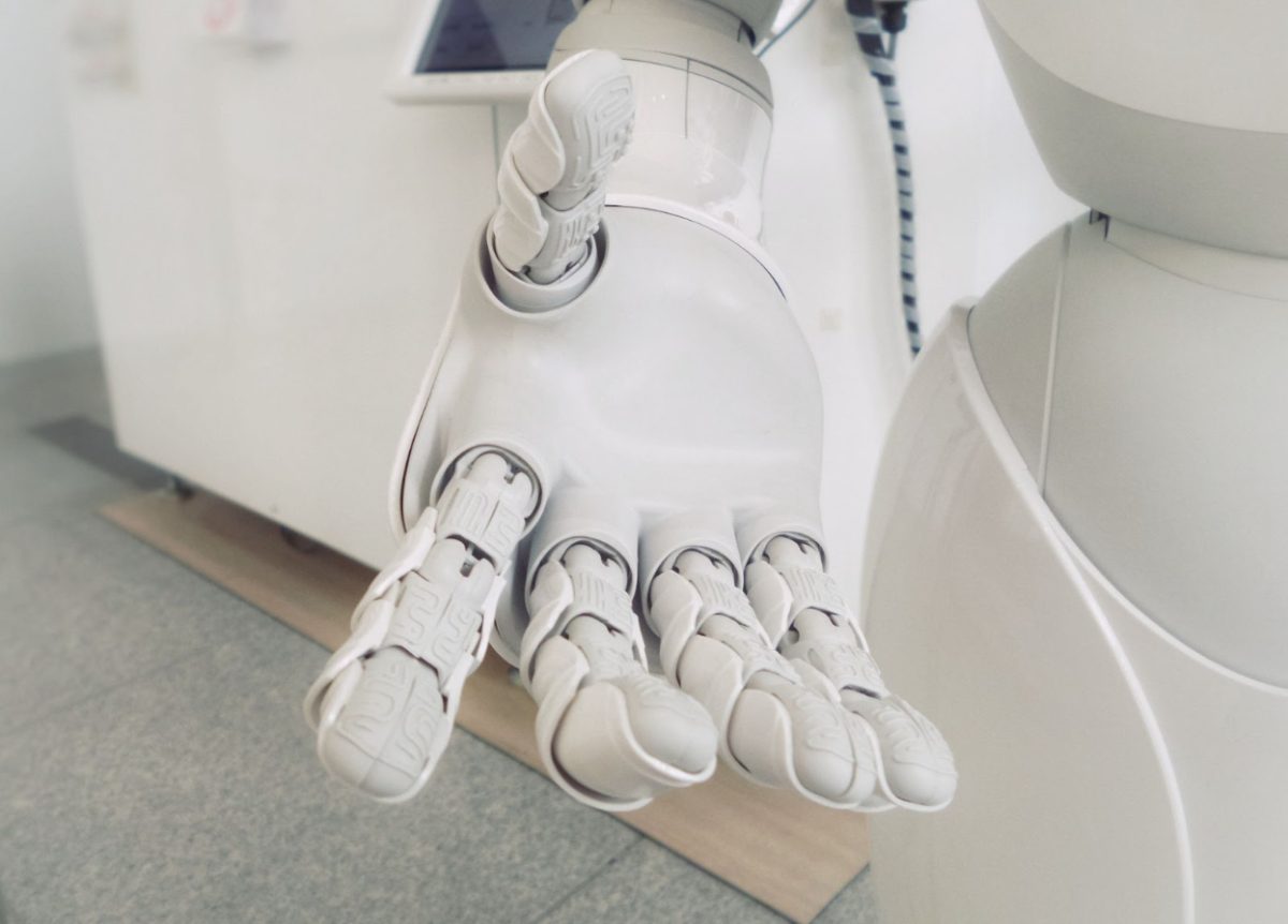 Here is a complex robotic hand reaching out as a welcoming gesture. Do you side with AI or do you back away from the knowledge of what AI can do to you? (Photo Credit: Possessed Photography / Unsplash)