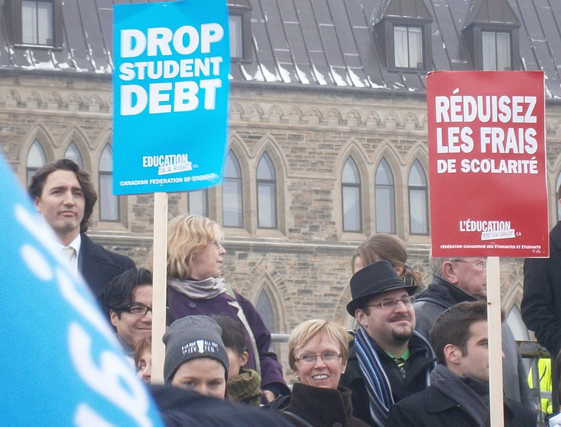 The United States is not alone in its struggle with student loan debt. Pictured above, Justin Trudeau, the Prime Minister of Canada, is protesting high tuition costs with picketers in 2012. In 2022, total federal student loan debt in Canada was $23.5 billion. (Photo Credit: Skimel, CC BY-SA 4.0 , via Wikimedia Commons)
