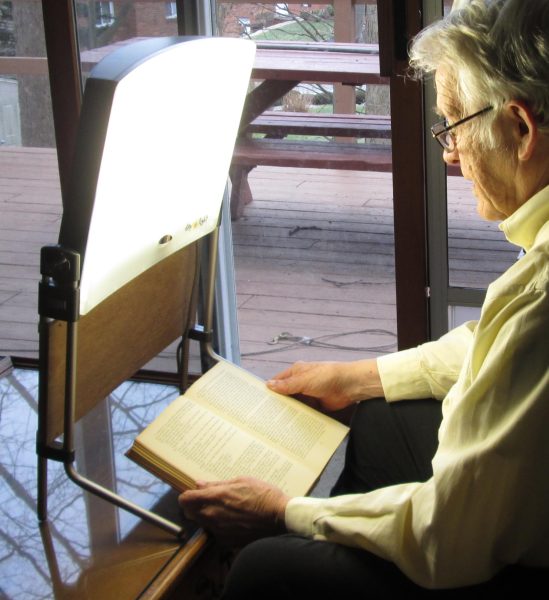 Pictured is a man partaking in light therapy, a common medical treatment for seasonal affective disorder. (Photo Credit: Lou Sander, CC BY-SA 4.0 , via Wikimedia Commons)