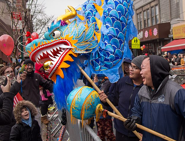 Lunar New Year is a great celebration of camaraderie and kinship each year. Pictured is a New York City Lunar New Year parade in which no one is left out; even a small bird has the chance to join in on the holiday’s festivities as it encounters the lively dragon dance. (Photo Credit: Rhododendrites, CC BY-SA 4.0 , via Wikimedia Commons)