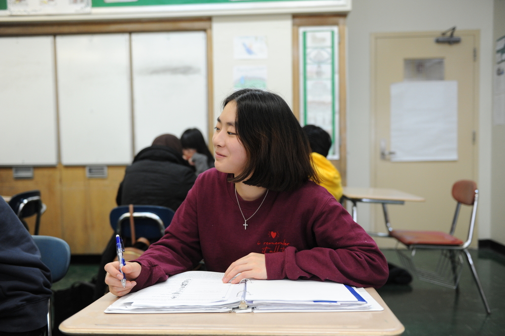A student takes in a captivating lesson in Latin, a language that requires the utmost attention and rigorous note-taking in order to achieve mastery in it. 