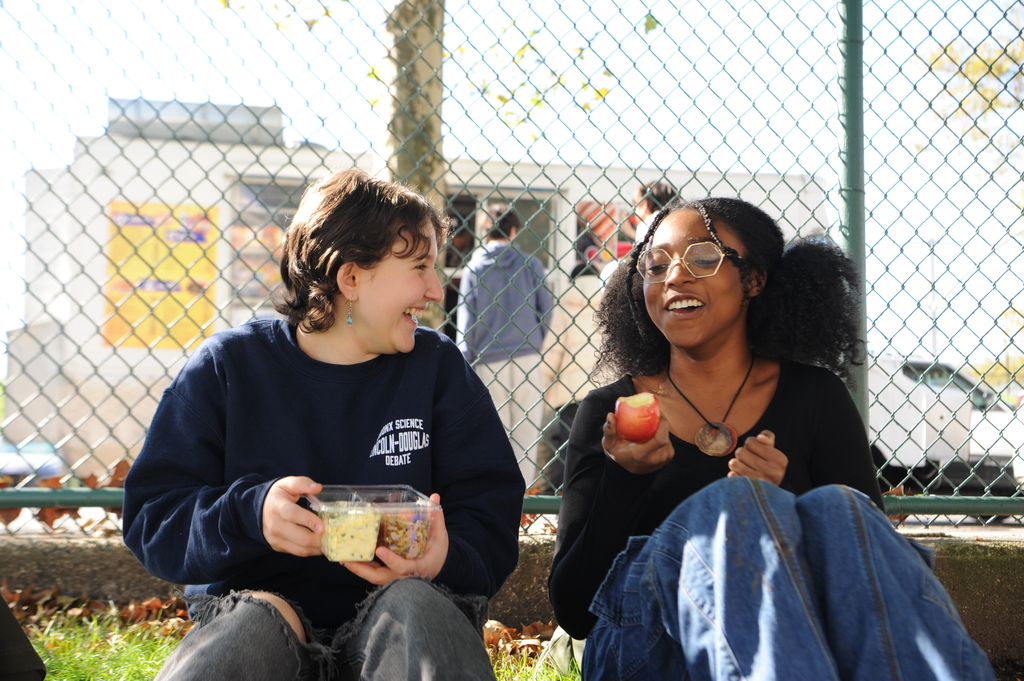 Here, two students eat lunch on campus and enjoy a friendly chat during a free period. 