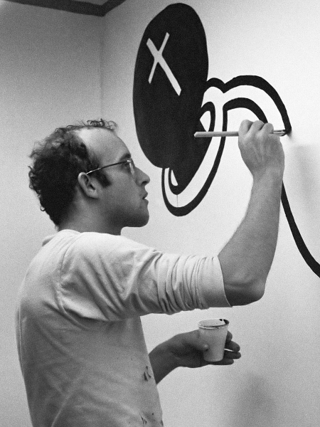 Here is Keith Haring meticulously painting in the Stedelijk Museum in Amsterdam in 1986. (Photo Credit: Rob Bogaerts (Anefo), CC0, via Wikimedia Commons)