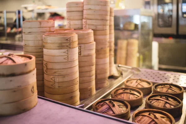 The wooden containers hold the treasures of delectable dim sum. (Photo Credit: kofookoo.de / Unsplash)
