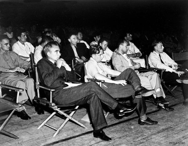 Feynman’s years with the Manhattan Project brought the brazen young scientist into close contact with the world’s greatest physicists and mathematicians. At the second row of seats, Feynman sits next to Oppenheimer. (Los Alamos National Laboratory, via Wikimedia Commons)