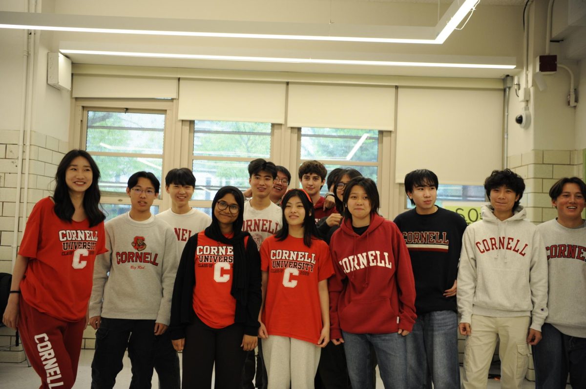 A large group of students show off their matching Cornell merchandise.
