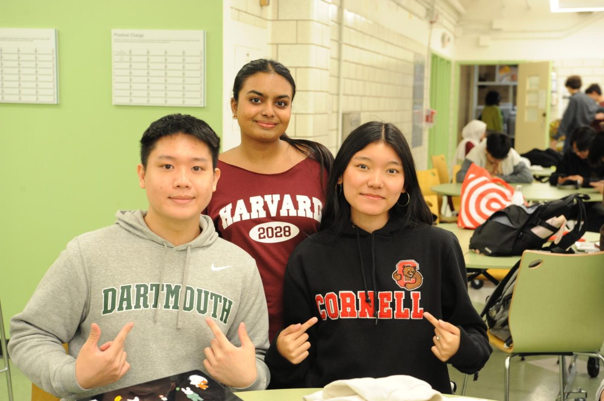 Ryan Ng ’24, Umme Anushka ’24, and Saldon Tenzin ’24 show off their Dartmouth, Cornell, and Harvard merchandise.
