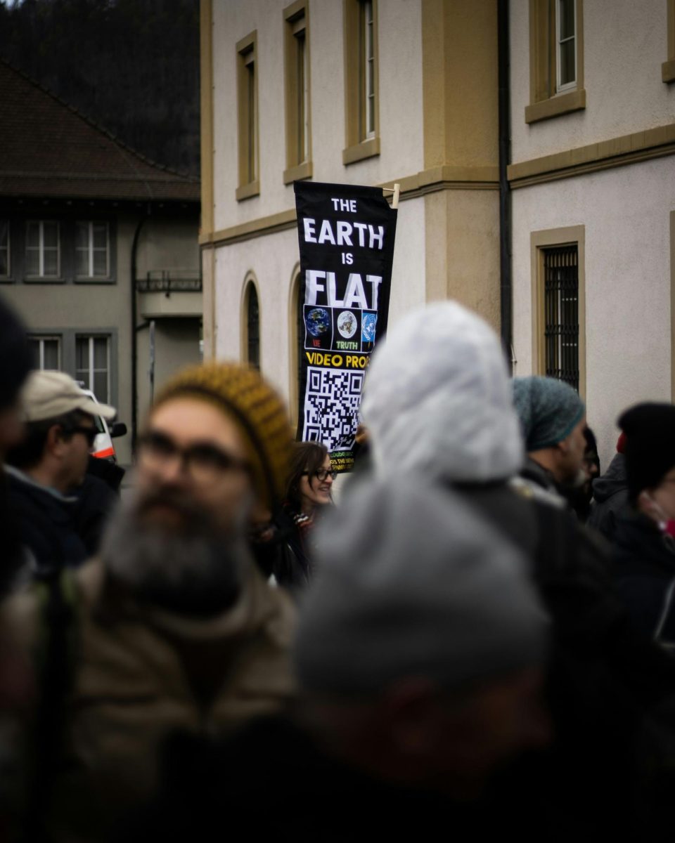 %E2%80%9CThe+Earth+is+Flat%21%E2%80%9D+reads+a+sign+that+a+protester+holds+up+in+Liestal%2C+Switzerland%2C+during+a+protest+against+COVID-19+restrictions+during+the+pandemic.+%28Photo+Credit%3A+Kajetan+Sumila+%2F+Unsplash%29++%0A+%0A