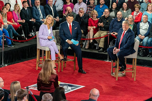 During a live Fox News Channel Town Hall, Donald J. Trump is shown, happily,  listening to a question coming from the audience. (Photo Credit: The White House from Washington, DC, Public domain, via Wikimedia Commons)