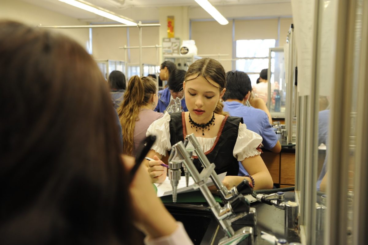 Students at Bronx Science always manage to mingle creativity with scientific discipline. Here, Harper Quill ’27 completes lab work in costume.