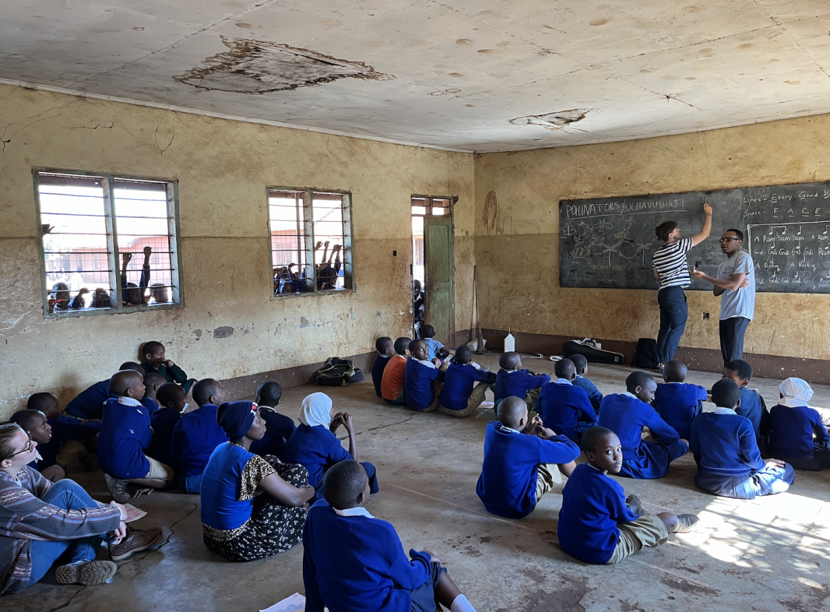 Michael Boaz and another volunteer teach a class while students look in through the windows.