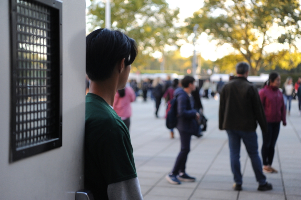 A student welcomes prospective students and their families at the Bronx Science entrance.