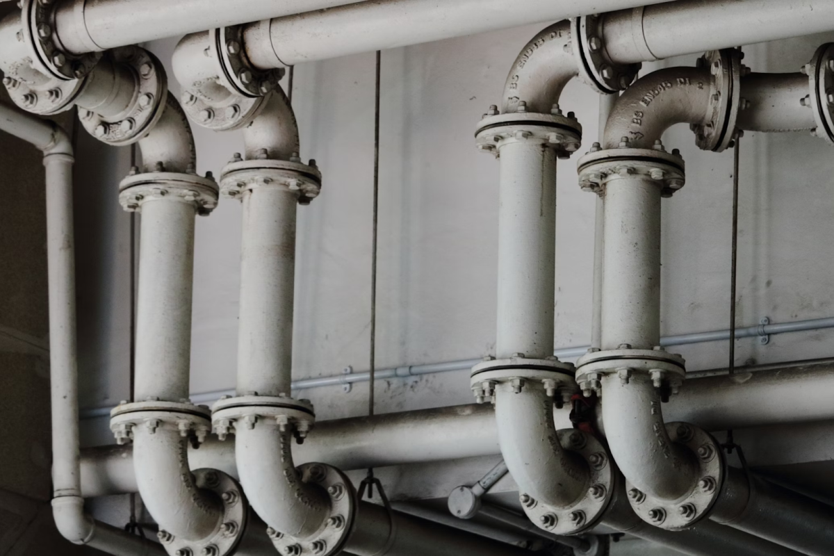 Pictured is an intricately plumbed network of drainage pipes. The usage of the pipes can be discerned by the thickness of the flange and the diameter of the pipe itself. (Photo Credit: Samuel Sianipar / Unsplash)