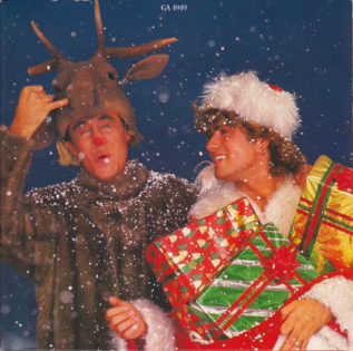 The album cover of ‘Last Christmas’ features a photograph of Wham! members Andrew Ridgeley (left) and George Michael (right) in extravagant Christmas costumes. (Image Credit: Fair Use, Wikimedia Commons)

