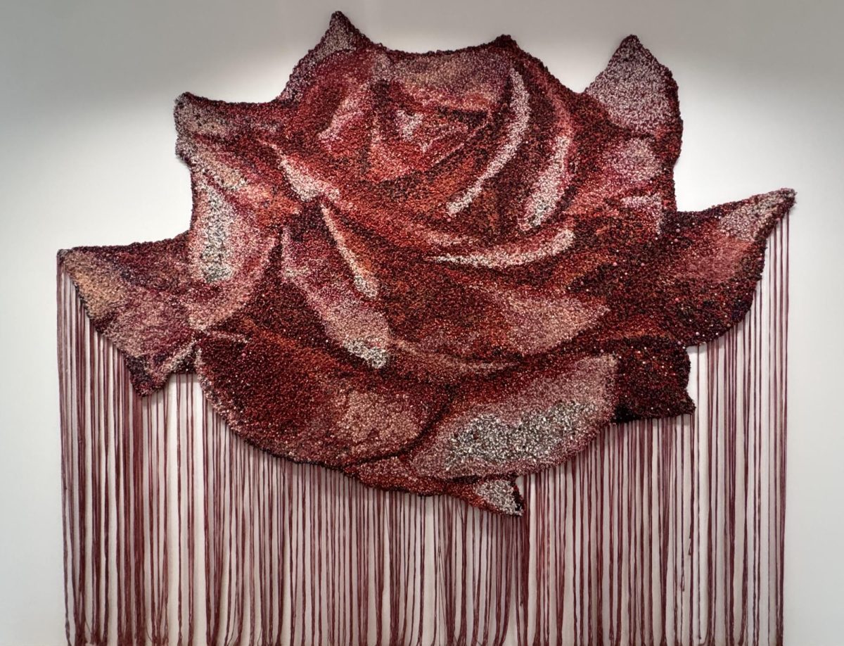 ‘For the ones we carry’ (2023–2025) is a large, multicolored beaded tapestry at 108 ½ × 121 ¾ × 1 inches composed of twine, rope, fabric, wood, plastic, glass, stones, beads, spiral, and sea shells. 