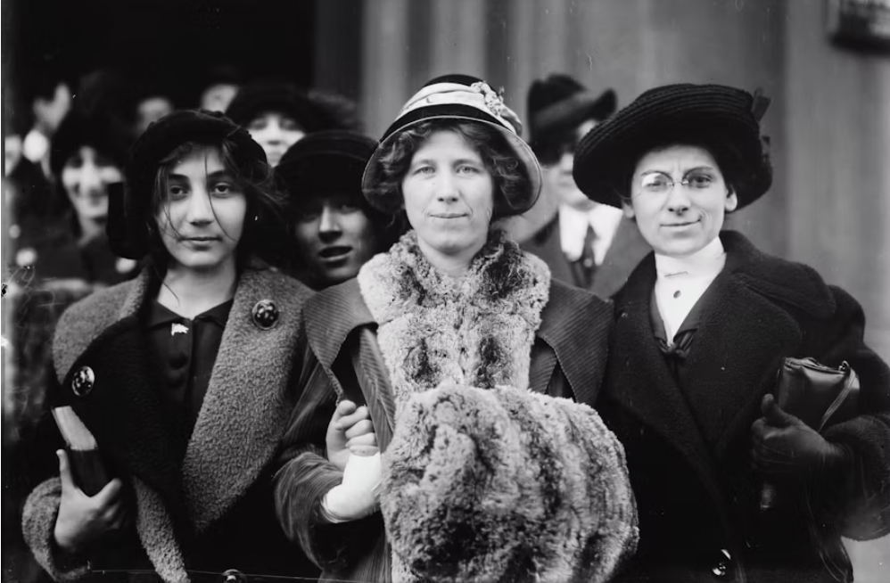 From left to right, pictured is a fourteen-year-old striker and suffrage and labor activist Flora Dodge "Fola" La Follette (1882-1970) along with the social reformer and missionary Rose Livingston, and a young striker, during a garment strike in New York City in 1913. (Photo Credit: Library of Congress, Public domain, via Wikimedia Commons; Glass negative from the George Grantham Bain Collection, 1913. Library of Congress Prints & Photographs Division)