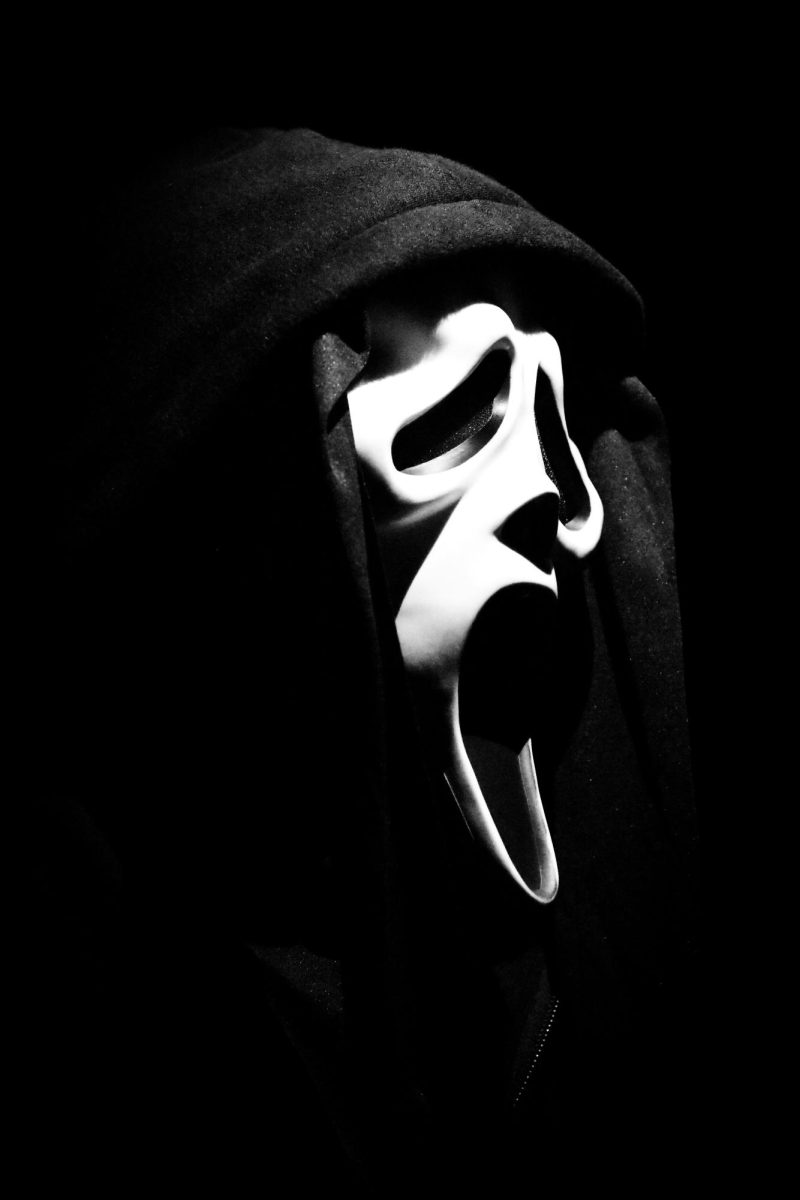 The image depicts a famous horror movie character, Ghostface from ‘Scream,’ who is known as a remarkable and nostalgic character from a popular slasher film series. This character represents a long-lasting love of horror from audiences. (Photo Credit: Nik / Unsplash) 