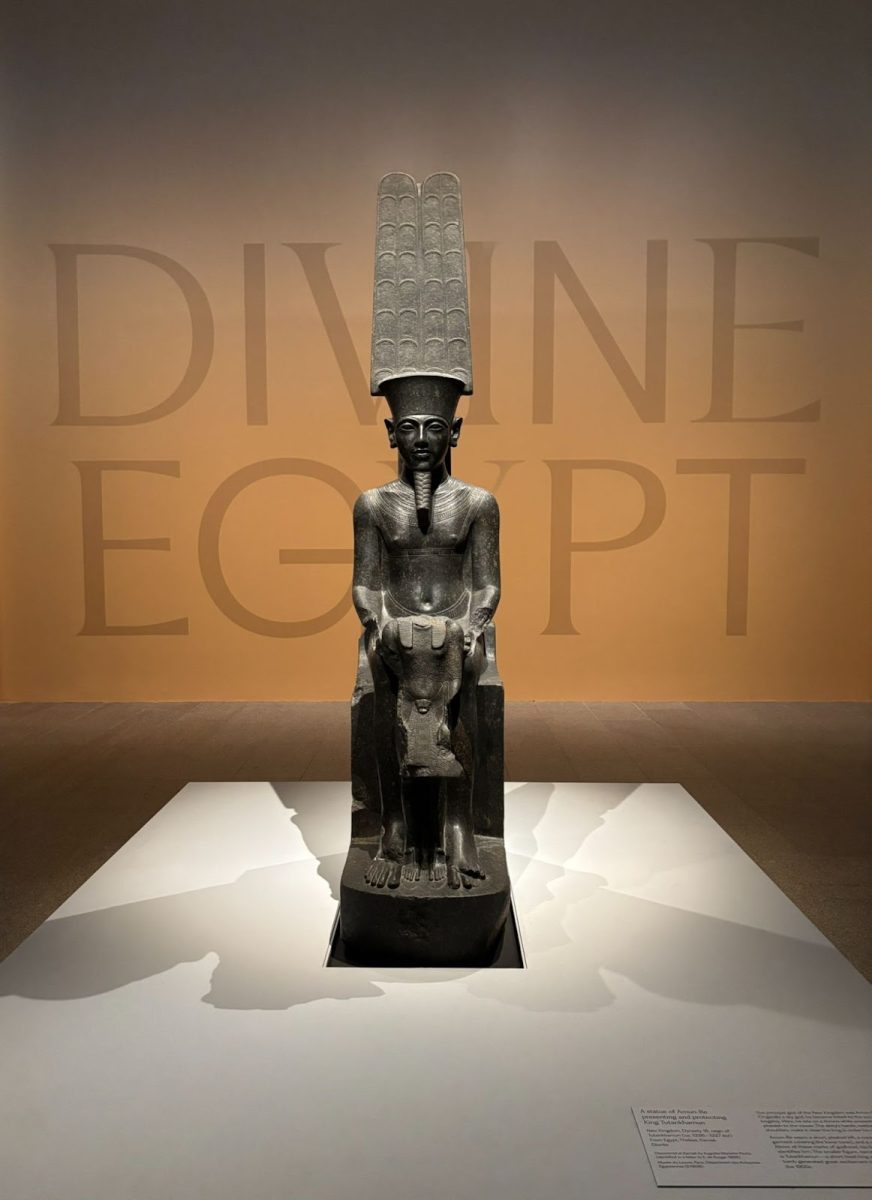 Pictured above is the display of the entrance to the exhibition of ‘Divine Egypt.’ Amun-Re is protecting King Tutankhamun. With physique and height, the divinity of the god in comparison to the king sets a precedent for the importance of Egyptian gods. 