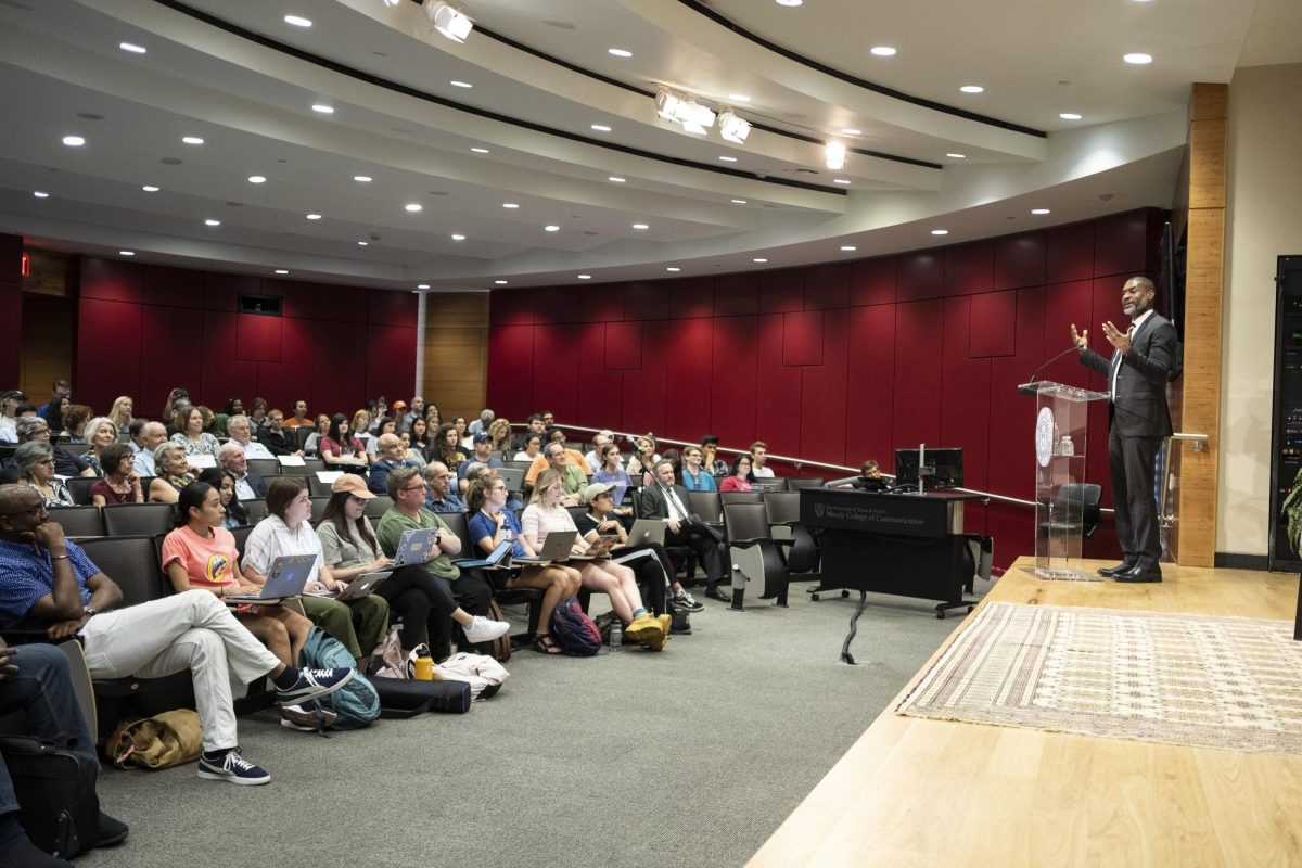 Pictured is a lecture taking place with a class of students at Moody College, the communication college at The University of Texas at Austin. (Photo Credit: Moody College of Communication from Austin, USA, CC BY-SA 2.0 , via Wikimedia Commons)

